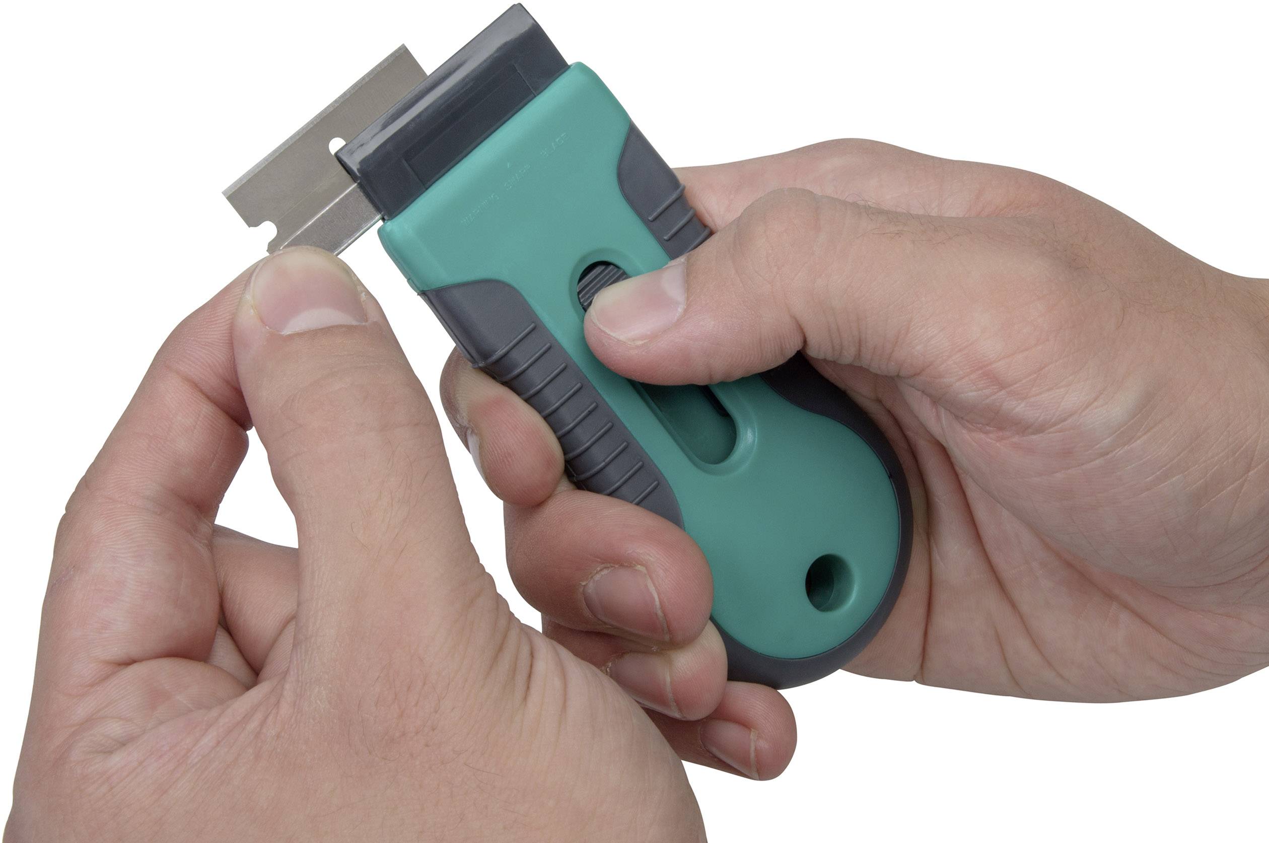 Eine Person hält ein grünes Schneidwerkzeug und befestigt eine silberne Klinge darin.