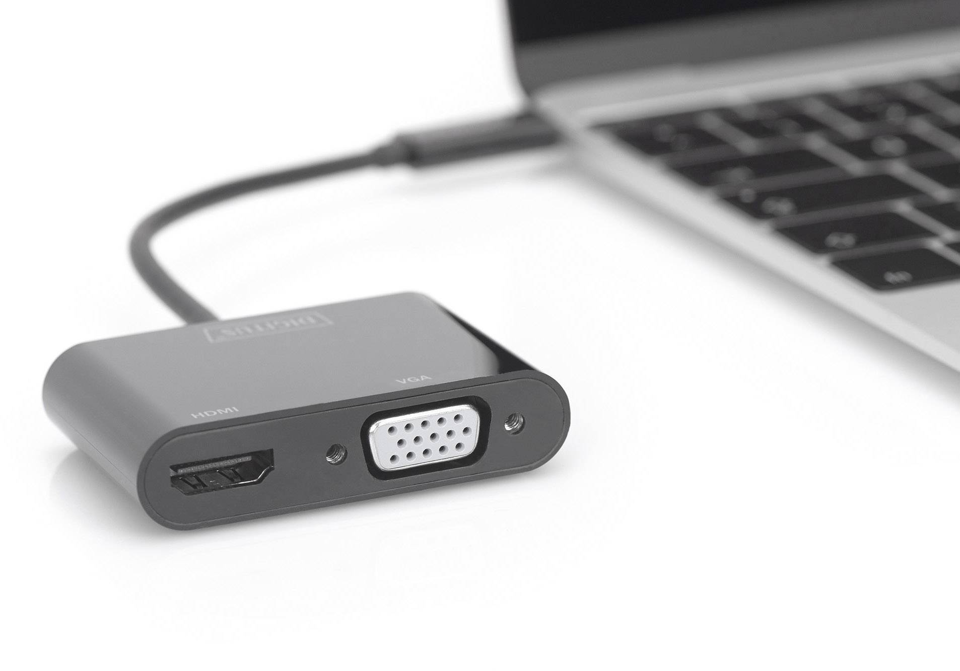 Ein schwarzer USB-Adapter mit HDMI- und VGA-Anschluss ist an einen Laptop angeschlossen.