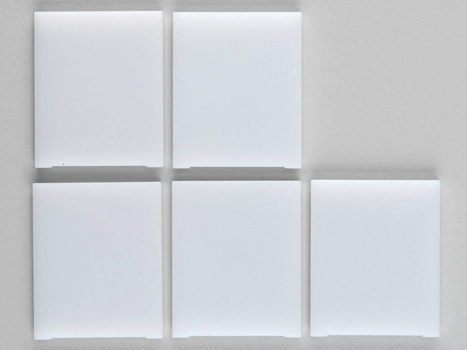 Fünf weiße, quadratische Fliesen sind in einer unvollständigen 2x3-Anordnung auf einem grauen Hintergrund angeordnet.