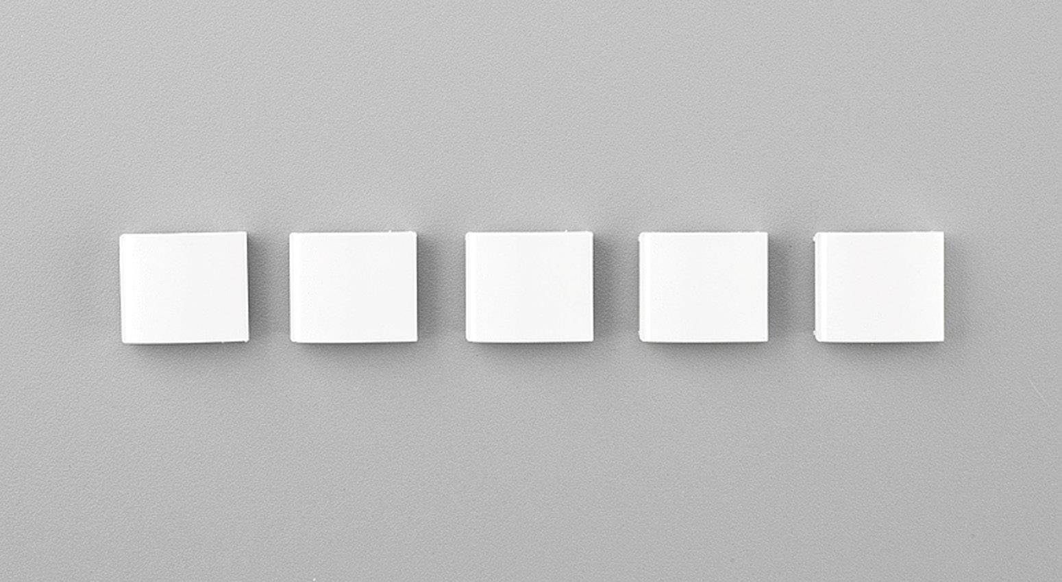 Fünf weiße quadratische Blöcke sind gleichmäßig nebeneinander auf einer grauen Hintergrundfläche angeordnet.