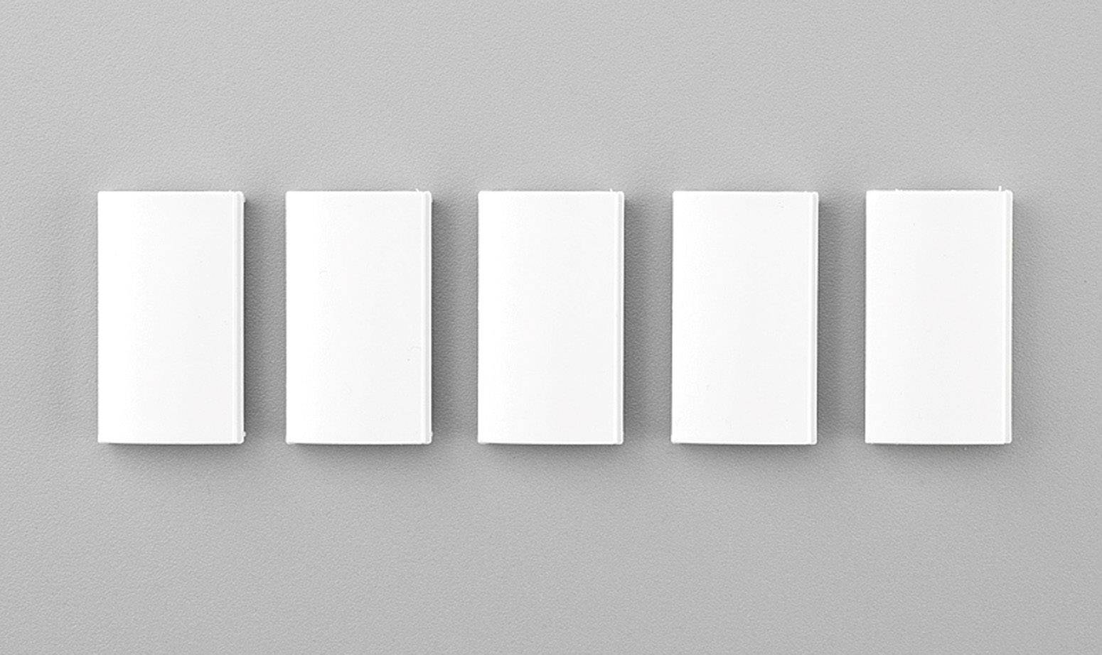 Fünf rechteckige, weiße Objekte nebeneinander auf grauem Hintergrund, gleichmäßig angeordnet.