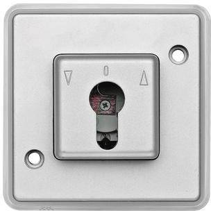 Ein quadratisches Schlüsselschaltergehäuse mit Pfeilsymbolen. Hauptsächlich verwendet, um elektrische Systeme ein- oder auszuschalten.