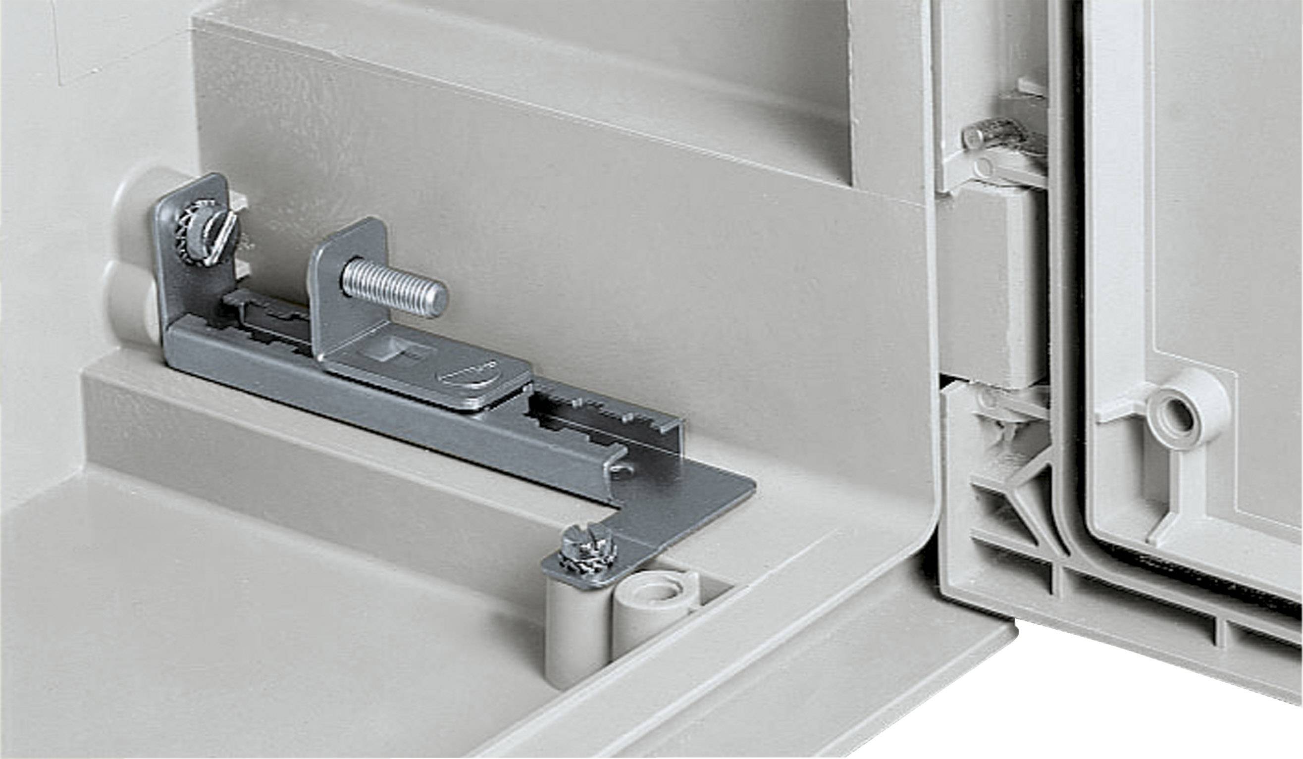 Metallmechanismus in einem grauen Gehäuse, bestehend aus Schrauben und Bolzen. Dient zur Sicherung von Gehäuseteilen.