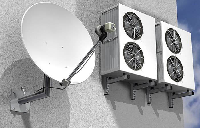 Satellitenschüssel und drei Klimaanlagen-Außengeräte an einer Gebäudefassade montiert.