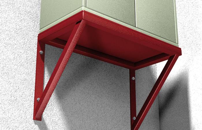 Ein Metallschrank ist an einer Wand montiert, unterstützt von roten Metallwinkeln. Wand und Schrank haben eine grob strukturierte Oberfläche.