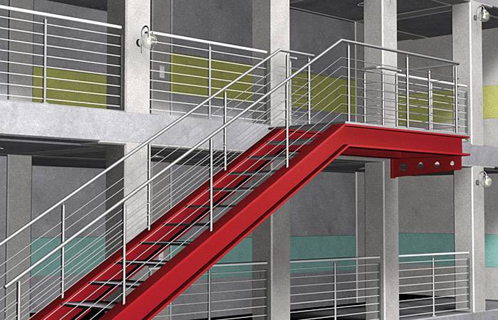 Ein rotes Treppengeländer in einem modernen mehrstöckigen Gebäude, umgeben von grauen Betonwänden mit bunten Paneelen.