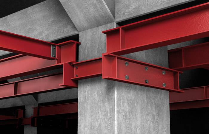 Rote Stahlträger, die in einem Betongebäude miteinander verbunden sind, zeigen die Struktur und Stabilität des Bauwerks.