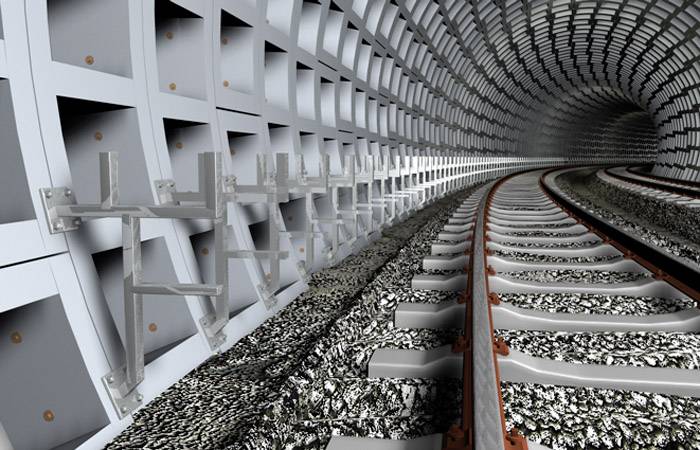 Ein Tunnel mit Schienen und verstärkten Betonwänden, die sich in die Ferne erstrecken. Metallrahmen sind an den Wänden befestigt.