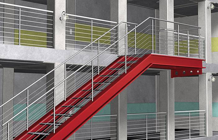 Rotes Treppenhaus in einem modernen Gebäude mit metallenen Geländern und Betonwänden, führt zu einer oberen Etage mit Balkonen.