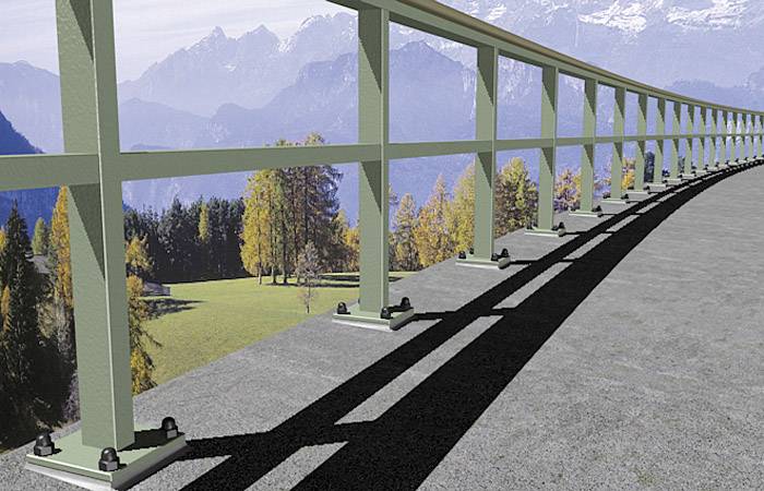 Metallgeländer entlang einer Asphaltstraße mit Blick auf eine malerische Berglandschaft und herbstliche Bäume im Hintergrund.