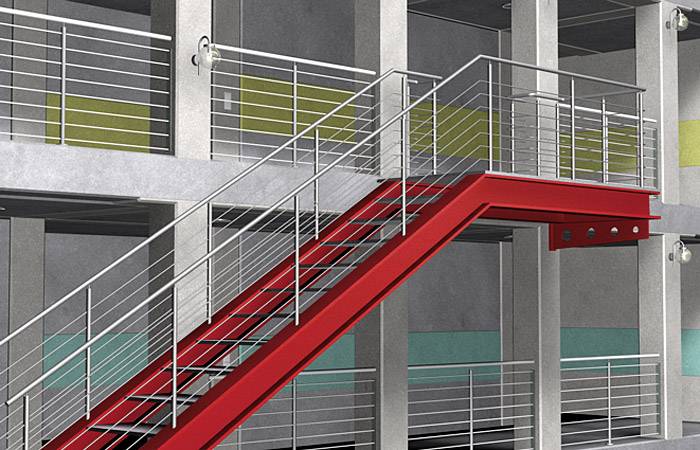 Rote Metalltreppe in einem modernen Gebäude, umgeben von grauen Wänden und farbigen Akzentflächen in Gelb und Türkis.