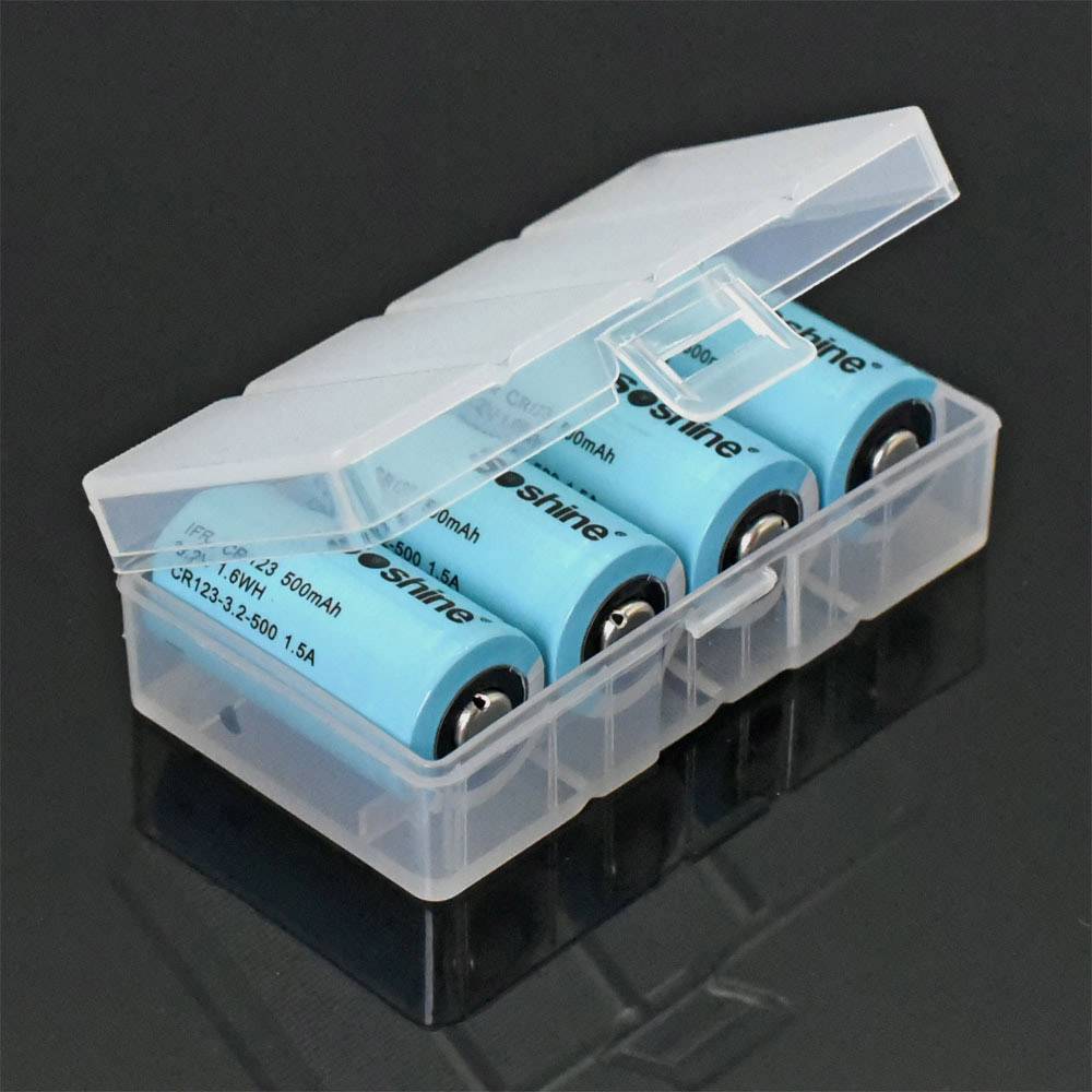 Ein transparentes Kunststoffetui enthält vier blaue AA-Batterien, die nebeneinander angeordnet sind.