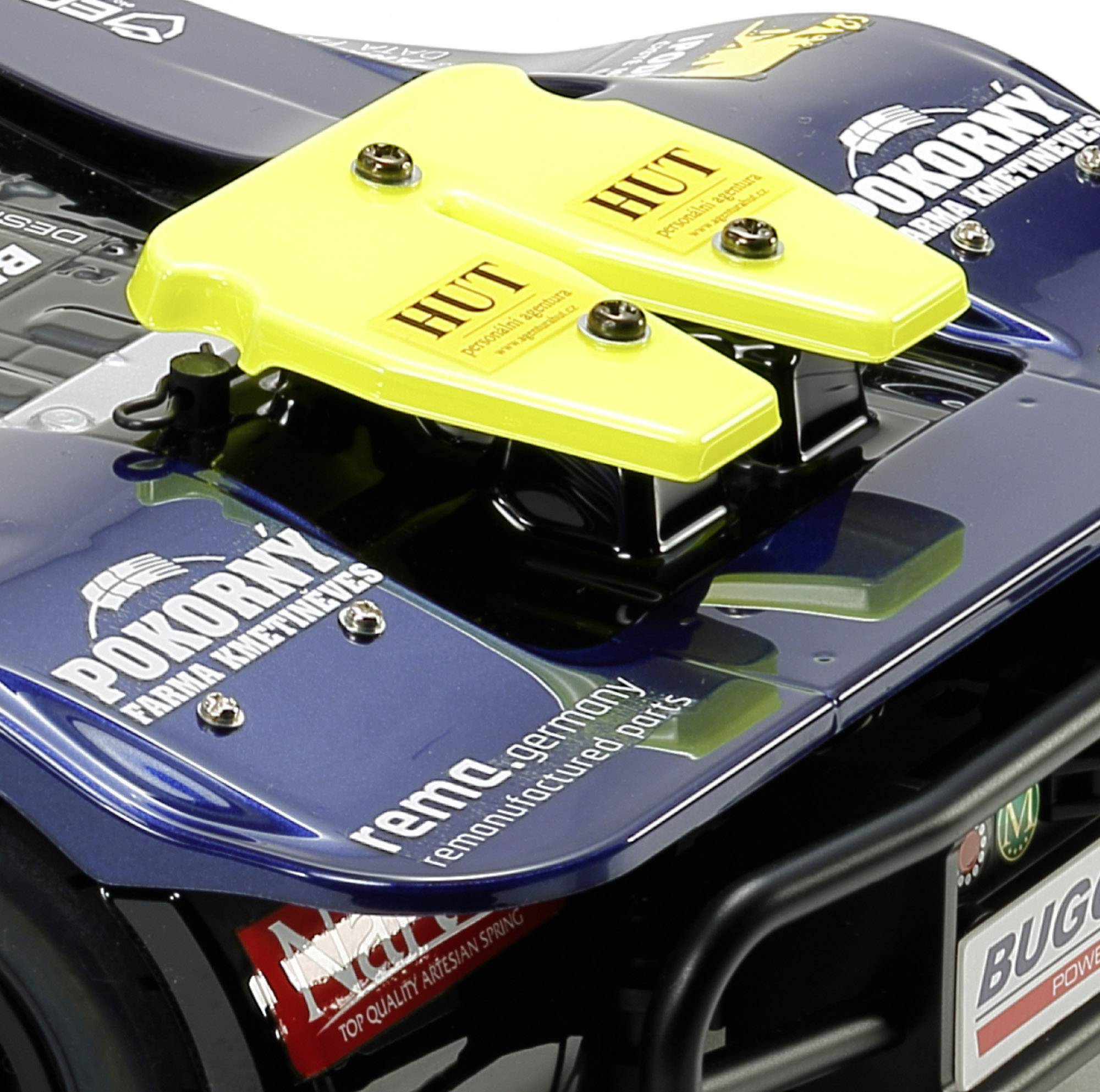 Rennauto-Heck mit gelbem Spoiler und Logos unterschiedlicher Marken, darunter 'POKORNY Frank Remax', 'HUT', und 'Buggyra'.