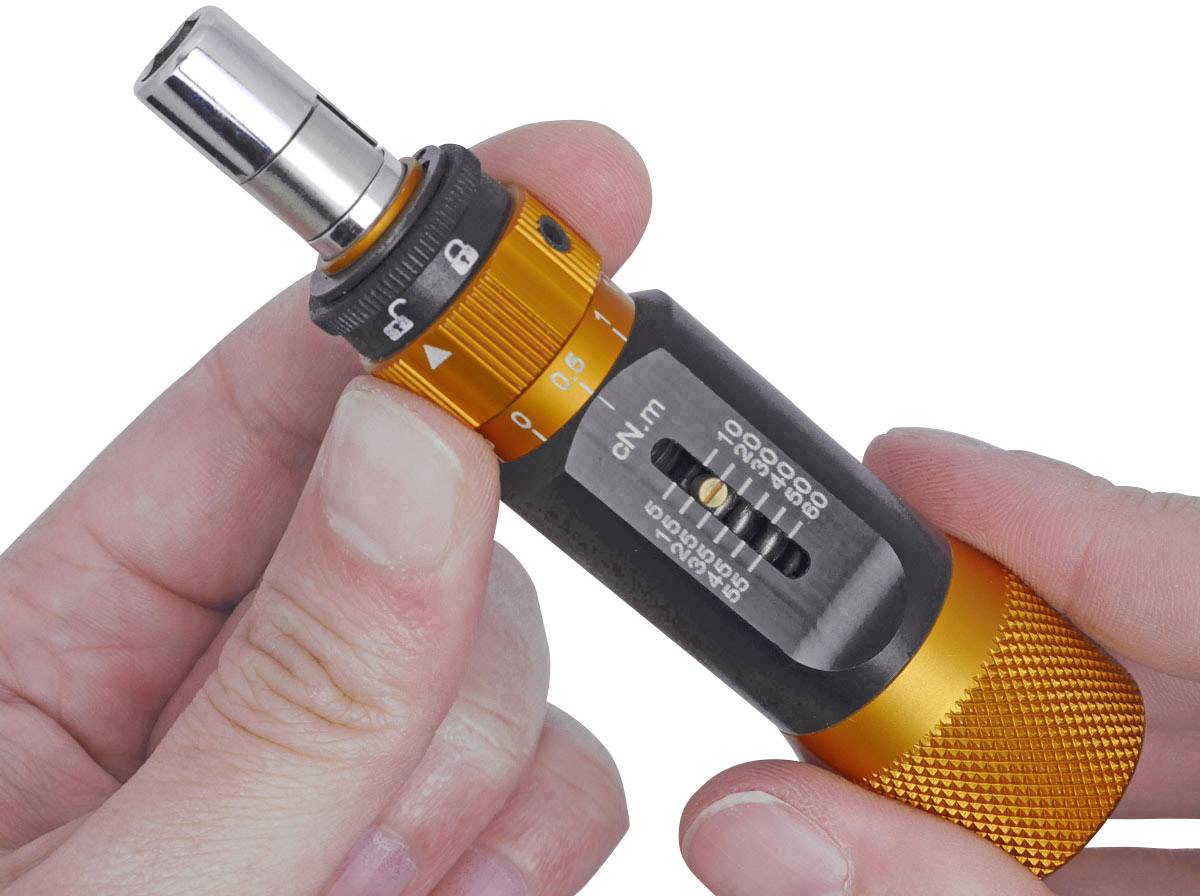 Eine Hand hält ein orangefarbenes Drehmomentwerkzeug mit Skalenanzeige, das für präzise Anziehmoment-Einstellungen an Schrauben verwendet wird.