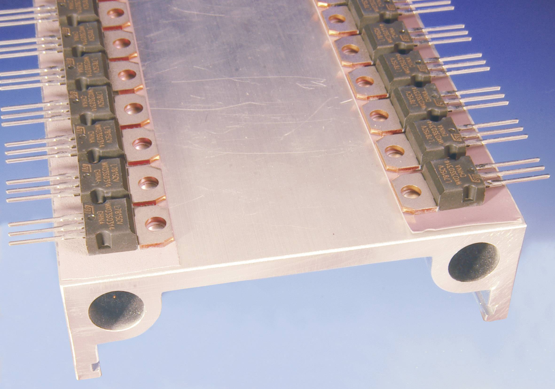 Ein Metallstreifen mit mehreren kleinen, gleichmäßig angeordneten elektrischen Komponenten und herausragenden Stiften, die für Elektronik verwendet werden.