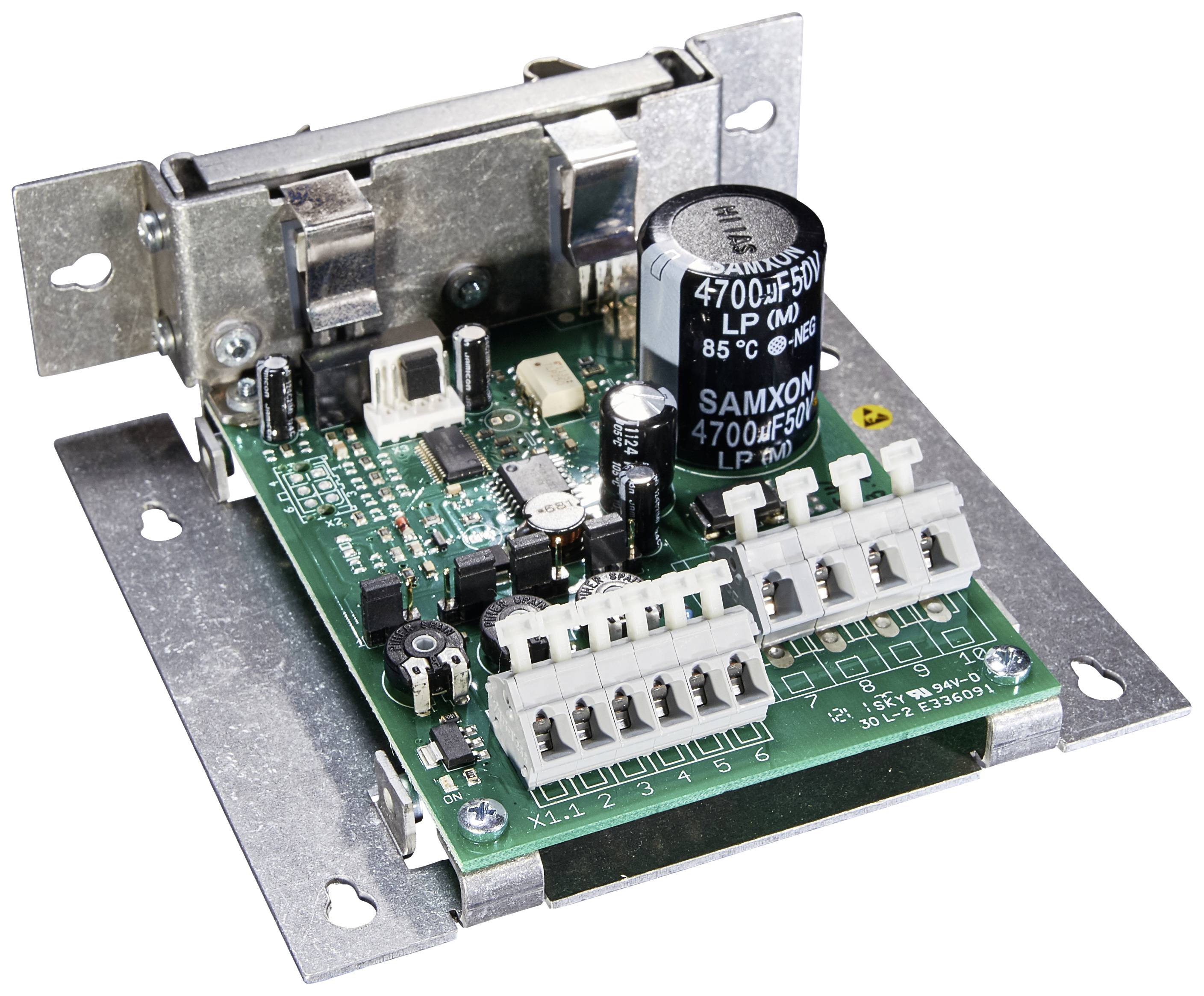 Eine elektronische Platine mit mehreren Anschlüssen, Widerständen und einem großen Kondensator, auf einer Metallhalterung montiert.