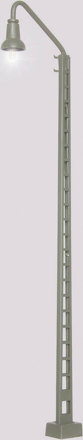 Eine hohe Straßenlaterne mit einem gebogenen Arm und einem leuchtenden Lampenschirm, montiert auf einem strukturierten Mast.