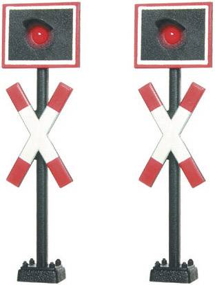 Zwei Spielzeug-Bahnübergangsschilder mit rotem Licht und rot-weißen Kreuzen auf schwarzem Pfosten, die Stoppsignale darstellen.