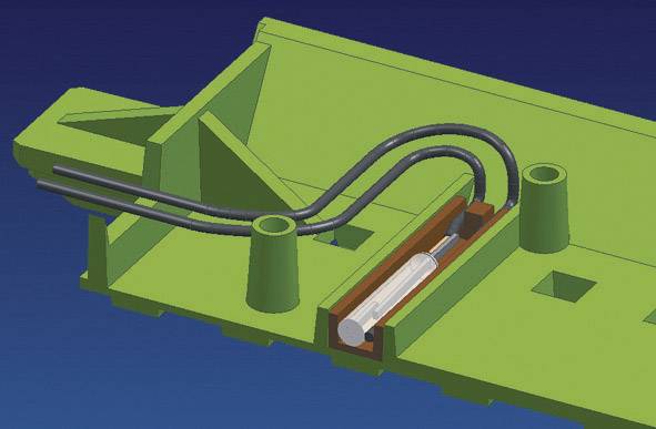 Ein grünes mechanisches Bauteil mit zwei länglichen Hohlräumen, schwarzer Schlauch und Metallzylinder in einem der Hohlräume integriert.