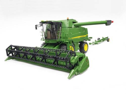 Eine grüne Mähdreschermaschine vor weißem Hintergrund, die für Erntearbeiten im landwirtschaftlichen Bereich verwendet wird.