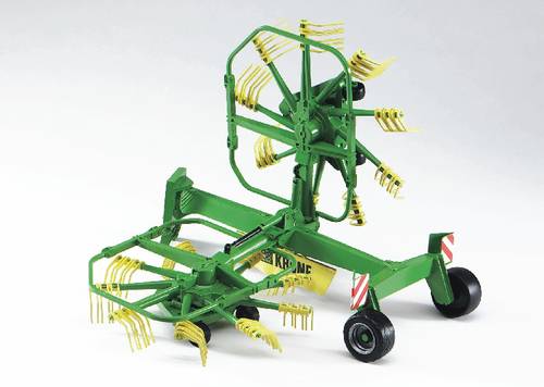 Ein grüner Heuwender mit gelben Zinken steht auf Rädern. Er wird in der Landwirtschaft zur Heuernte verwendet.