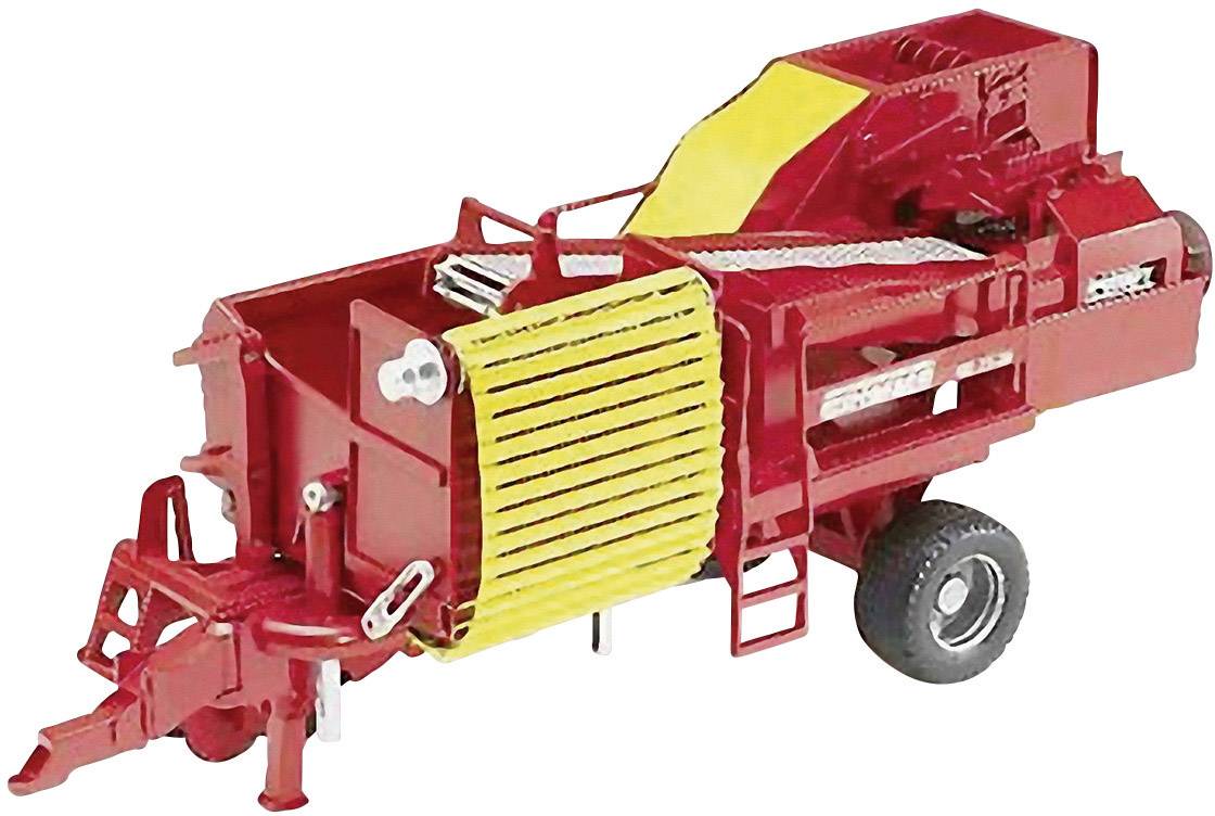 Eine rote landwirtschaftliche Maschine mit gelben Details auf zwei Rädern, vermutlich zur Ernteverarbeitung oder Heuballenproduktion.