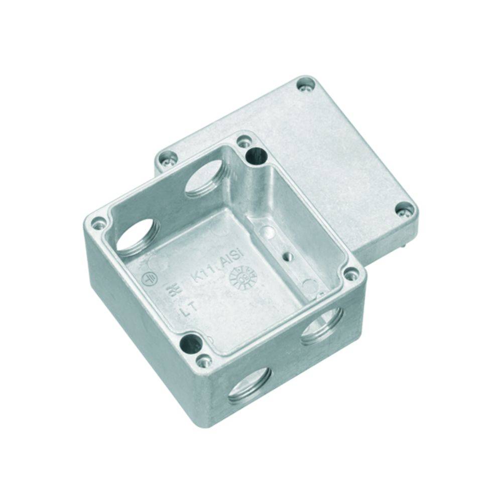Rechteckige, offene Metallanschlussdose mit vier seitlichen Öffnungen zur Kabeldurchführung. Deckel neben der Dose platziert.