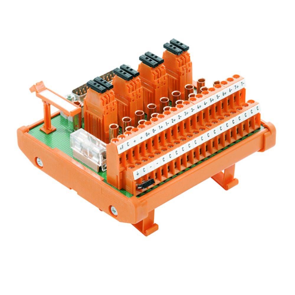 Ein orangefarbenes elektrisches Verbindungsmodul mit mehreren Anschlüssen, das auf einer grünen Grundplatte montiert ist. Technikdetail.