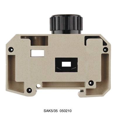 Terminalblockgehäuse mit schwarzem Drehknopf oben, beige Kunststoffgehäuse, abgebildet sind Löcher und Schlitze für Elektronikmontage.