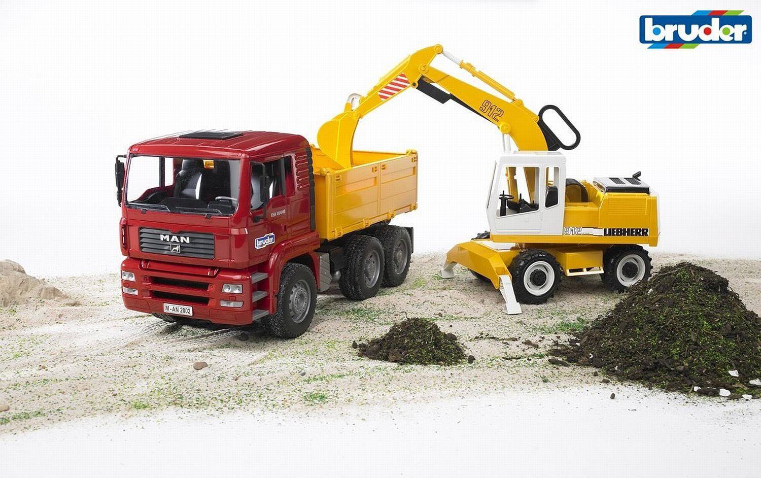 Ein roter Spielzeug-LKW und ein gelber Spielzeug-Bagger auf einer Sandfläche. Der Bagger hebt Erde und lädt sie auf den LKW.