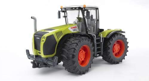 Ein grüner Spielzeugtraktor mit großen roten Rädern steht auf weißem Hintergrund; er hat markante Details und Beschriftungen.