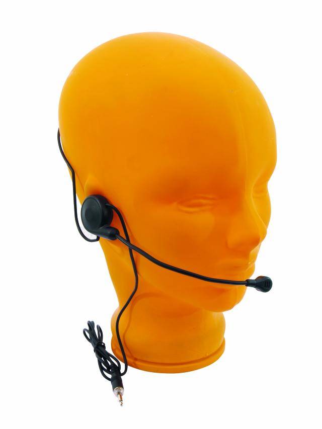 Eine orangene Schaufensterpuppe trägt ein schwarzes Headset mit Mikrofon, verbunden über ein Kabel mit einem Audio-Stecker.