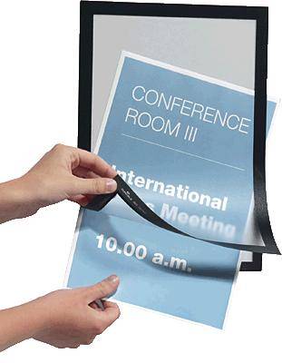 Person legt ein blaues Schild mit der Aufschrift 'CONFERENCE ROOM III - International Meeting - 10.00 a.m.' in einen schwarzen Rahmen.
