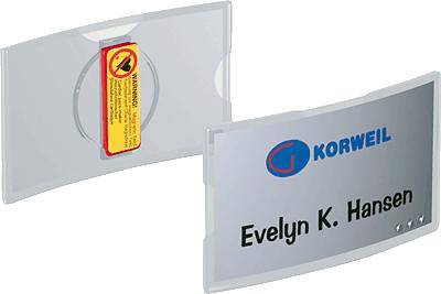 Zwei Türschilder mit dem Text 'Evelyn K. Hansen' und dem Logo von Korweil. Eines zeigt eine gelbe Warnungsetikette auf der Rückseite.