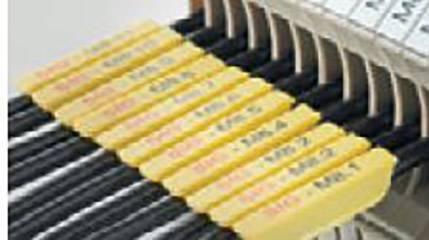 Eine Reihe von beschrifteten gelben Kabeln in einem Anschlussverteiler.