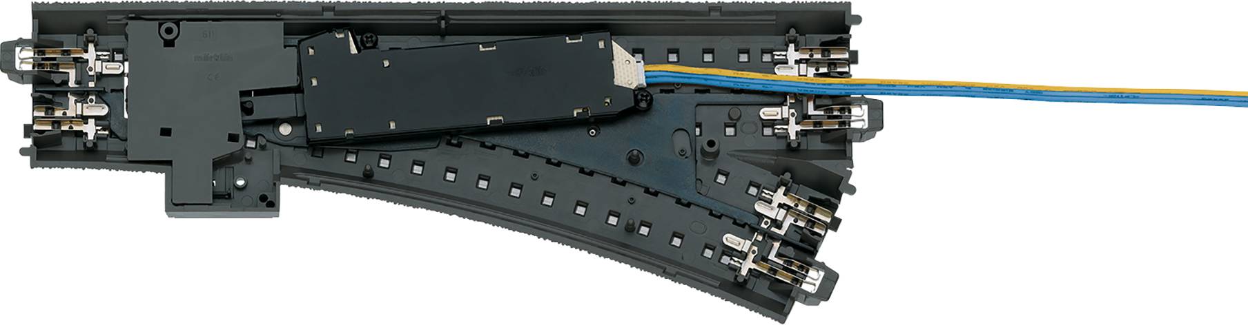 Elektrische Modelleisenbahnweiche mit schwarzer Kunststoffschiene und blauen sowie gelben Kabeln für die Stromversorgung.