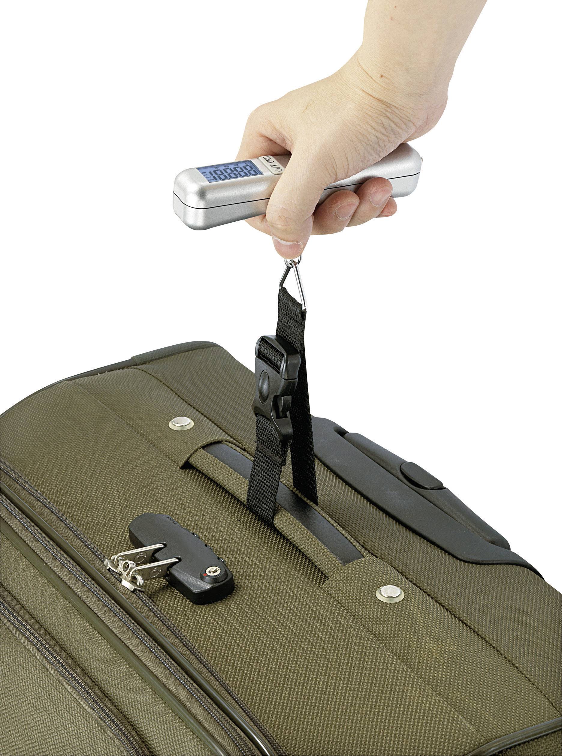 Eine Hand hält eine tragbare Waage, die an einem Gepäckstück befestigt ist, um dessen Gewicht zu messen.