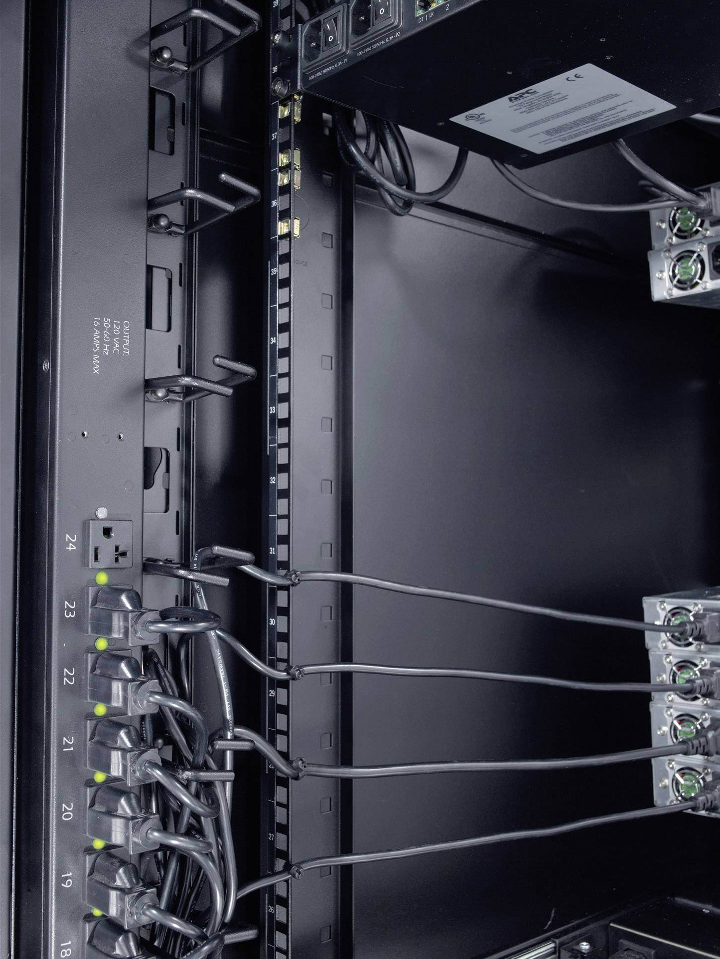 Ein Serverrack mit mehreren Stromanschlüssen und Kabeln, die in verschiedenen Ports eingesteckt sind.