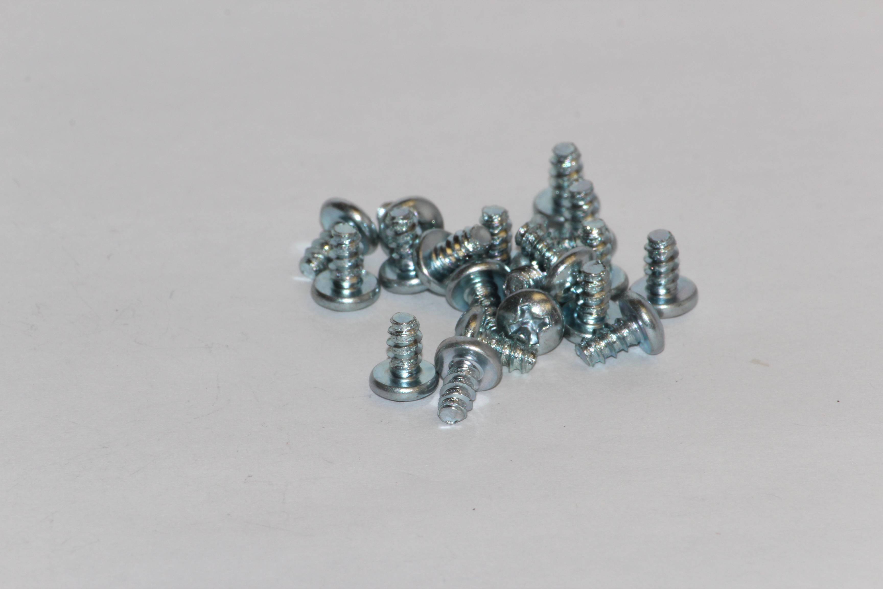 Eine Ansammlung von silbernen Metallschrauben auf einem weißen Hintergrund.