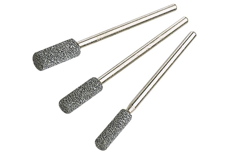 Drei zylindrische Schleifstifte aus grauem Material mit metallischen Griffen, gestaffelt nach Größe, auf weißem Hintergrund.