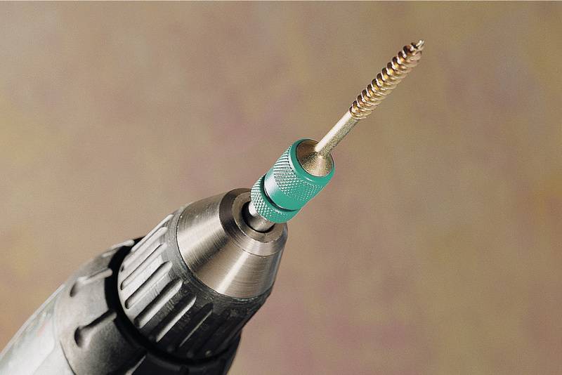 Ein Akkubohrer mit einer grünen Drahtbürste als Aufsatz, die zum Polieren oder Reinigen von Oberflächen verwendet wird.