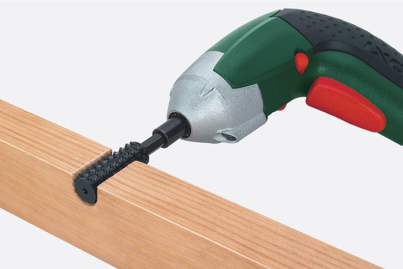 Akkuschrauber mit Dübelbohreraufsatz bohrt in Holz.