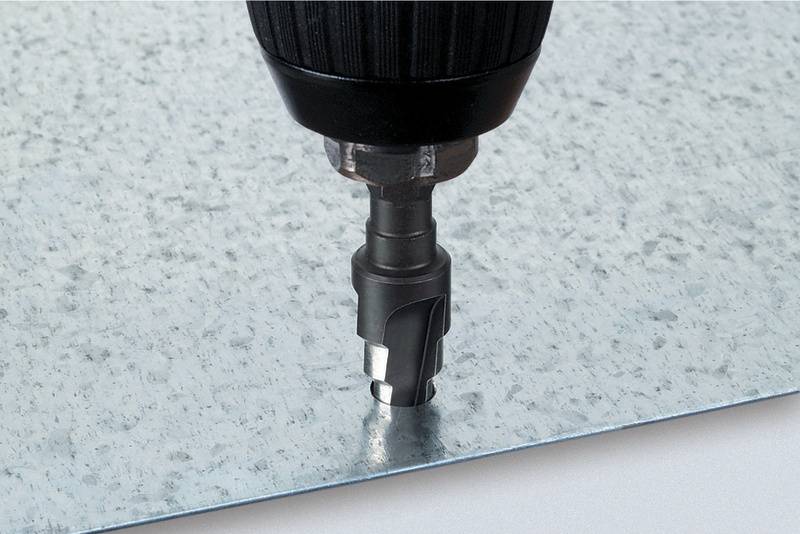 Eine Bohrmaschine bohrt ein Loch in eine Metallplatte.