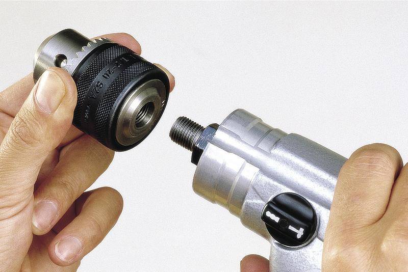 Eine Person hält einen Schraubenzieher mit einem Schnellspannbohrfutter, bereit, es am Werkzeug zu befestigen.