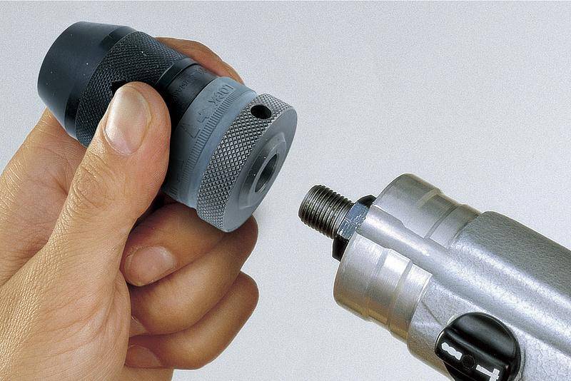 Eine Hand hält ein Bohrfutter, das an ein Elektrowerkzeug mit Gewindeanschluss angebracht wird.