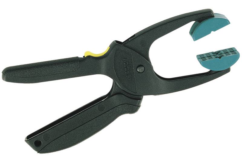 Eine schwarze Handzwinge mit blauen Gummigriffen und einem gelben Schieber, die zum Halten von Gegenständen verwendet wird.