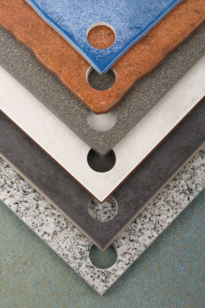 Verschiedene Schichten von Materialien in verschiedenen Farben und Texturen übereinander gestapelt, mit runden Ausschnitten an den Ecken.