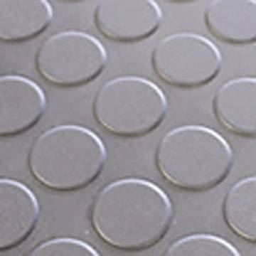Kreisförmiges Muster aus leicht erhabenen Punkten auf einer glatten, metallisch wirkenden Oberfläche.