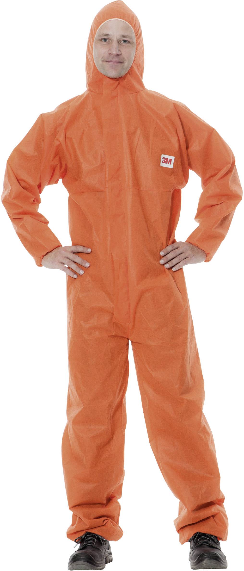 Person in einem orangefarbenen Schutzanzug mit Kapuze, steht mit den Händen an der Hüfte, vor neutralem Hintergrund.