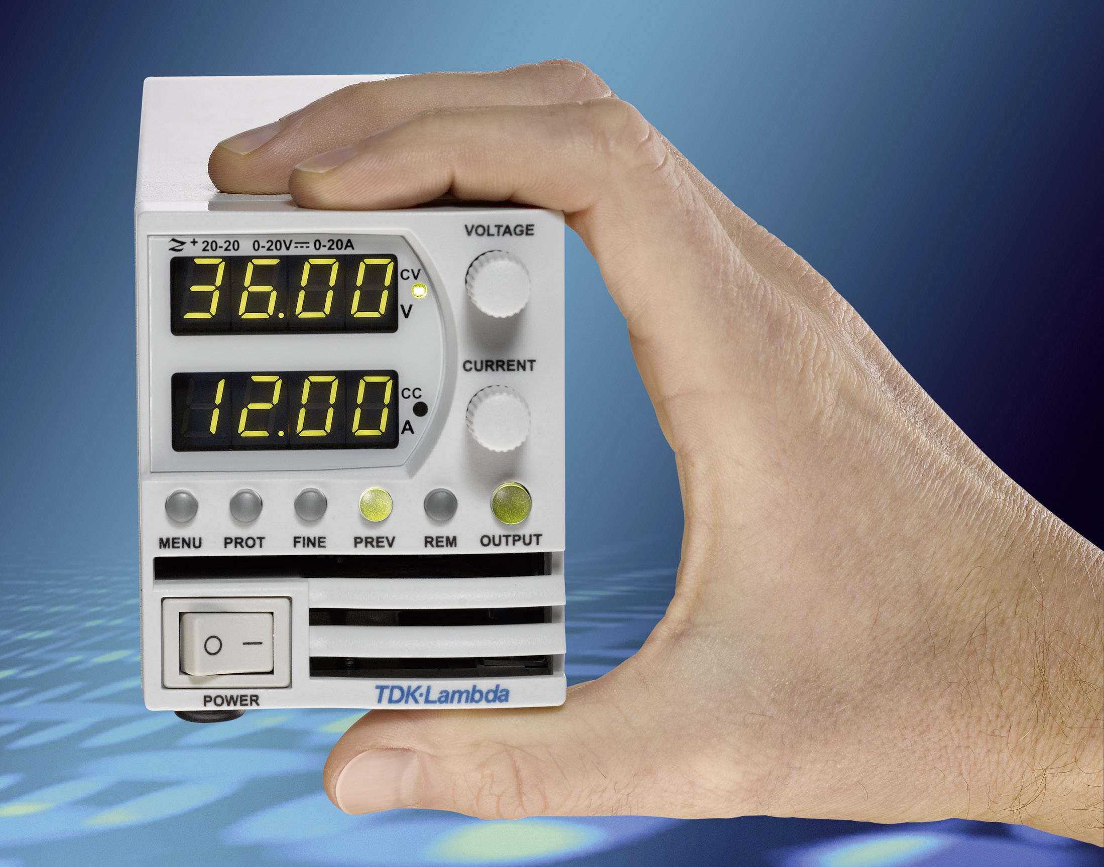 Eine Hand hält ein kleines, digitales Spannungs- und Strommessgerät. Die Anzeige zeigt '36,00' Volt und '12,00' Ampere.